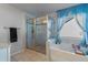 This bathroom features a tub with blue curtains and glass enclosed shower at 5915 Partners Pass, Cumming, GA 30028