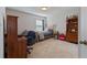 This cozy bedroom features neutral walls, carpet, and a wood bedframe and desk at 5915 Partners Pass, Cumming, GA 30028