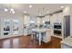 Well-lit kitchen featuring stainless steel appliances, custom cabinets, granite counters, and an island with seating at 5915 Partners Pass, Cumming, GA 30028