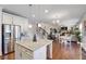Open concept kitchen with stainless steel appliances and island, overlooking the dining and living areas at 5915 Partners Pass, Cumming, GA 30028