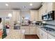 Bright kitchen featuring white cabinets, granite countertops, stainless steel appliances, and a view to the backyard at 5915 Partners Pass, Cumming, GA 30028