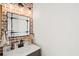 Stylish bathroom with a brick wall accent, modern lighting, and a vessel sink at 7880 Brands Hatch Blvd, Cumming, GA 30040