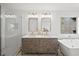 Modern bathroom with glass shower, soaking tub, double sink vanity, and a large window at 7880 Brands Hatch Blvd, Cumming, GA 30040
