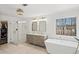 Modern bathroom with glass shower, soaking tub, double sink vanity, and a large window at 7880 Brands Hatch Blvd, Cumming, GA 30040