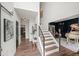 Open floor plan with hardwood floors, staircase, and living room with a white piano at 7880 Brands Hatch Blvd, Cumming, GA 30040