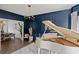Stylish living room featuring a white piano, navy blue walls, and open archway to dining area at 7880 Brands Hatch Blvd, Cumming, GA 30040