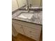 Bathroom vanity features white cabinets, granite countertop, and a modern faucet at 1075 Peachtree Walk # A205, Atlanta, GA 30309