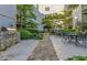 Serene courtyard with an outdoor kitchen, stone grill, seating, and lush landscaping at 1075 Peachtree Walk # A205, Atlanta, GA 30309