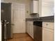 Galley kitchen features stainless steel appliances and white cabinets at 1075 Peachtree Walk # A205, Atlanta, GA 30309