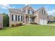 Beautiful two-story brick home featuring a covered porch and lush green lawn at 2031 Broadmoor Way, Fairburn, GA 30213