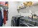 Modern laundry room with front loading washer and dryer, with wire shelves and storage at 2031 Broadmoor Way, Fairburn, GA 30213
