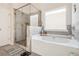 Bright bathroom with separate shower and soaking tub with marble style tile surround at 2031 Broadmoor Way, Fairburn, GA 30213