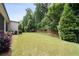 Lush backyard featuring a green lawn, mature trees, and a wooden fence, creating a private outdoor space at 10580 Grandview Sq, Johns Creek, GA 30097
