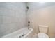 Bright bathroom showcasing a tub with tiled walls and a shower, alongside a standard white toilet at 10580 Grandview Sq, Johns Creek, GA 30097