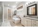 This bathroom features white cabinets, a soaking tub, dual vanity, and decorative framed mirrors at 10580 Grandview Sq, Johns Creek, GA 30097