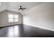 Spacious bedroom with hardwood floors, a ceiling fan, and a large window, offering ample natural light at 10580 Grandview Sq, Johns Creek, GA 30097