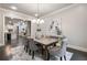 Open dining room with stylish chandelier and view of the kitchen at 10580 Grandview Sq, Johns Creek, GA 30097