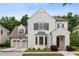 Charming two-story white brick home with a manicured lawn, arched entry, and attached two-car garage at 10580 Grandview Sq, Johns Creek, GA 30097