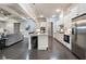 Open-concept kitchen with white cabinets and stainless steel appliances adjacent to the living area at 10580 Grandview Sq, Johns Creek, GA 30097