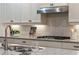Close-up of kitchen featuring white herringbone backsplash and stainless steel range hood at 10580 Grandview Sq, Johns Creek, GA 30097
