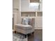 Close up of a chair in the living room with built in shelving, fireplace and an area rug at 10580 Grandview Sq, Johns Creek, GA 30097