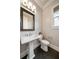 Elegant powder room featuring a pedestal sink, modern fixtures, and dark wood flooring at 10580 Grandview Sq, Johns Creek, GA 30097