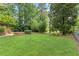 Expansive backyard with lush green grass and mature trees, with a staircase to the deck at 2789 Brookcliff Lndg, Marietta, GA 30062