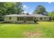 Spacious backyard featuring green lawn, mature trees, and a screened porch at 4062 Plantation Dr, Marietta, GA 30062