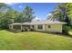 Spacious backyard featuring green lawn, mature trees, and a screened porch at 4062 Plantation Dr, Marietta, GA 30062