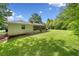 Spacious backyard featuring green lawn, mature trees, and a screened porch at 4062 Plantation Dr, Marietta, GA 30062