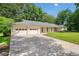 Charming single-story home featuring a three-car garage and a well-manicured lawn, all set beneath a clear blue sky at 4062 Plantation Dr, Marietta, GA 30062