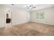 Neutral main bedroom featuring carpet, ceiling fan and ensuite bathroom with view to backyard at 4062 Plantation Dr, Marietta, GA 30062