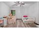 Bright bedroom features two twin beds, desk, modern ceiling fan, and wood grain flooring at 48 Old Canton Ne Rd, Cartersville, GA 30121