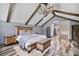 Main bedroom featuring exposed wood beams, wood grain floors, wood furniture, and barn door at 48 Old Canton Ne Rd, Cartersville, GA 30121