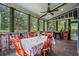 Screened deck features an outdoor dining table, a ceiling fan, and tree views at 48 Old Canton Ne Rd, Cartersville, GA 30121
