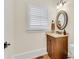 Bathroom with a wood vanity, round mirror, and shuttered window for natural light at 1029 Fairway Ne Ests, Atlanta, GA 30319