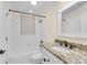 Bathroom with tub-shower combo, tile surround, and granite vanity with dark fixtures at 1029 Fairway Ne Ests, Atlanta, GA 30319