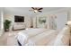 Bright bedroom features stylish white dresser, ceiling fan, ensuite bathroom, and a luxurious queen bed with white bedding at 1029 Fairway Ne Ests, Atlanta, GA 30319