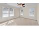 Bright bedroom features neutral carpet, ceiling fan, and three windows, offering a serene space at 1029 Fairway Ne Ests, Atlanta, GA 30319