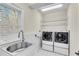 Well-lit laundry room featuring washer, dryer, sink, and metal shelving at 1029 Fairway Ne Ests, Atlanta, GA 30319