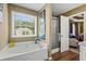 Bathroom featuring a large soaking tub, walk-in shower, and a bright window at 47 Powder Springs St, Hiram, GA 30141
