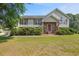 Charming home featuring a landscaped front yard with lush green lawn and covered entryway at 47 Powder Springs St, Hiram, GA 30141