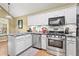 Well-equipped kitchen with granite counters, stainless appliances, and white cabinets at 47 Powder Springs St, Hiram, GA 30141