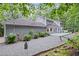 A spacious backyard featuring a lovely home with grey siding, string lights, and lush trees at 115 Leaf Lake Dr, Suwanee, GA 30024