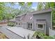 Exterior view of a home with a deck, gravel and lush trees at 115 Leaf Lake Dr, Suwanee, GA 30024