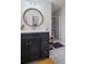 Bathroom featuring dark vanity, circular mirror, and tiled floors at 115 Leaf Lake Dr, Suwanee, GA 30024