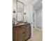 Bathroom with rustic vanity, sconces and doorway leading to the adjoining room at 115 Leaf Lake Dr, Suwanee, GA 30024