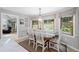 Bright dining area with wood table, chairs and window showcasing wooded exterior views at 115 Leaf Lake Dr, Suwanee, GA 30024