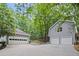 Two garages with ample space and an expansive drive-way, surrounded by mature trees at 115 Leaf Lake Dr, Suwanee, GA 30024