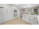 Bright kitchen features white cabinets, modern appliances, and an eat-in area near the large window at 115 Leaf Lake Dr, Suwanee, GA 30024